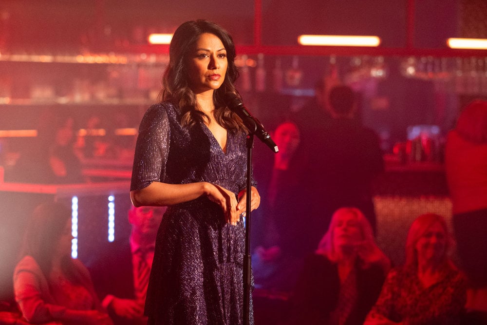 Rose performing at a bar with red-tinted lights on The Irrational Season 2 Episode 3