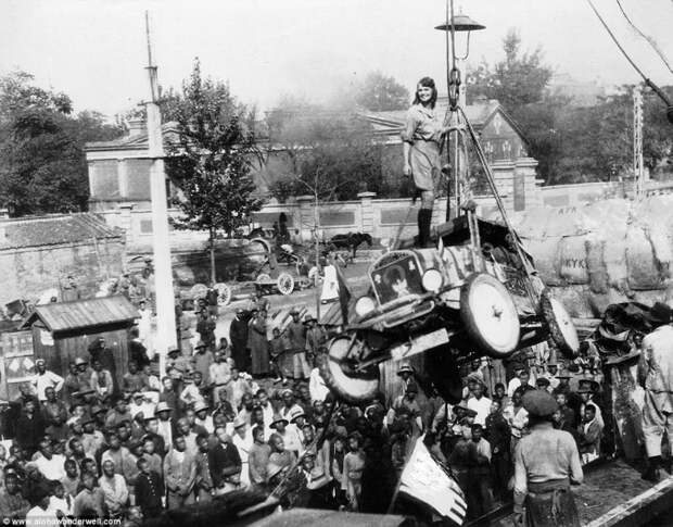 Алоха стоит на капоте своего знаменитого автомобиля Ford Model-T, который погружают на корабль, во время её тура по Африке, 1920-е годы. автопутешествие, путешествие, ретро фото