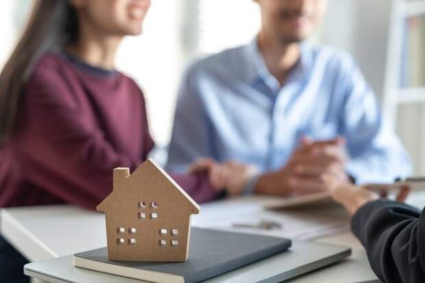 A small wooden house with couple blurred in background.