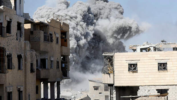 Дым после авиаудара по позициям боевиков в Ракке, Сирия