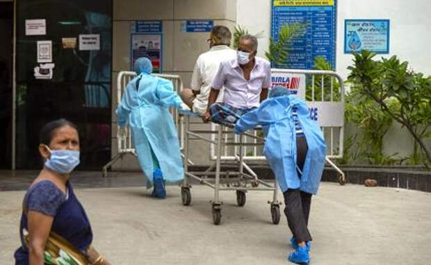 На фото: медицинские работники переводят пациента с вирусом COVID 19 в специальное отделение государственной больницы