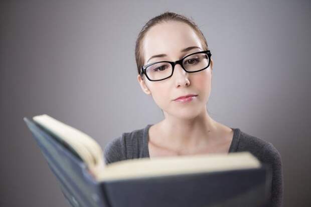 Девушка в очках читает книгу