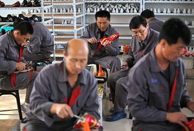 Северокорейские рабочие изготавливают обувь для игры в футбол. 24 октября 2012