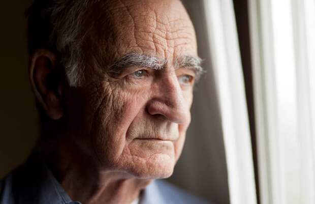 A visibly concerned person staring out of a window.