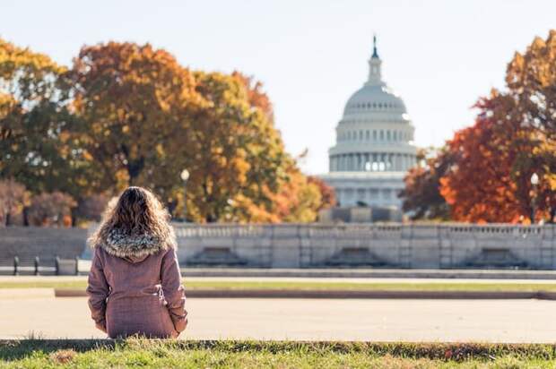 Woman sitting outside the capitol building on a fall day