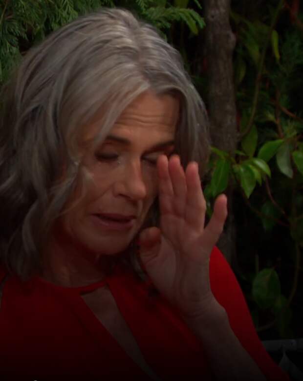 Fiona holds her hand up to her eye, upset, on Days of Our LIves