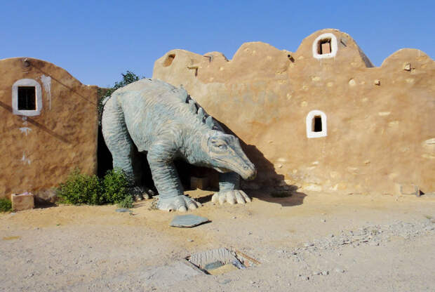 Динозавр на страже в старом парке в Тунисе