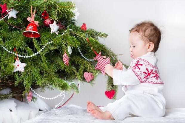 Малыш украшает елку