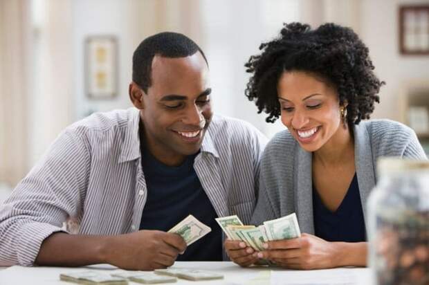 A couple counts the bills and coins they've saved in a jar.