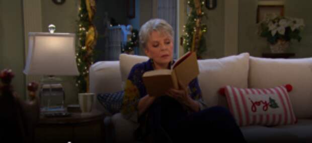 Julie sitting and reading a book on Days of Our Lives during the week of 12-23-24