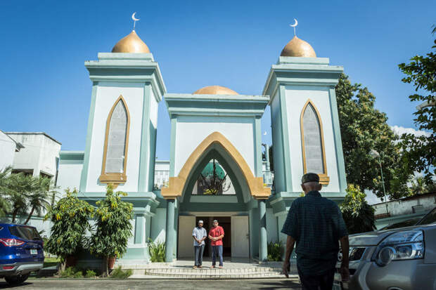 Men gather before Friday prayers in the parking lot outside the mosque in San Pedro Sula.