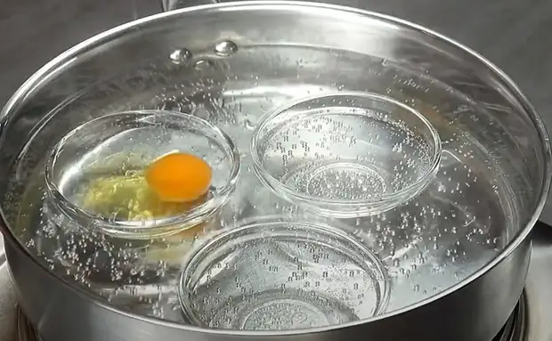 Яйца кладут в кипящую воду. Яйца в кружке кипятком. Разбить яйцо в кипяток. Сварение в кипятке яйцо. Приготовление вечной.
