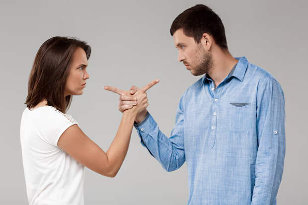 Young beautiful married couple posing grey wall