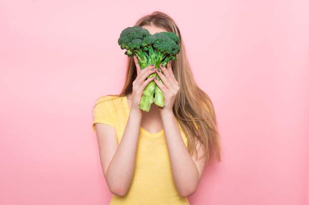 Woman have fun holding gluten-free organic green vegetable. Healthy nutrition food concept.