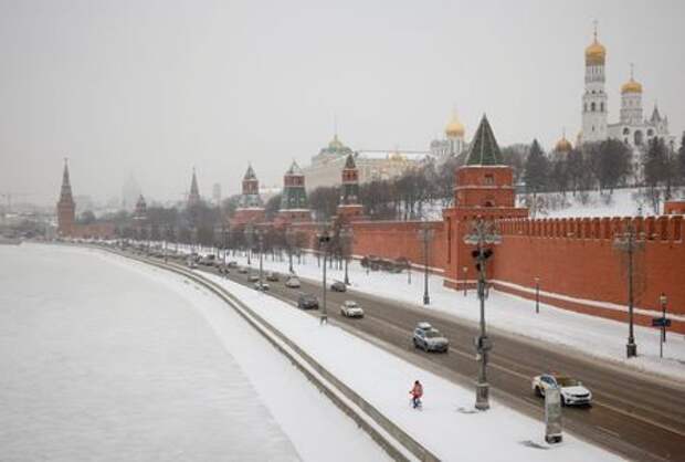 Cars drive along an embankment of the Moskva River near the Kremlin during snowfall in Moscow, Russia January 14, 2021. REUTERS/Maxim Shemetov