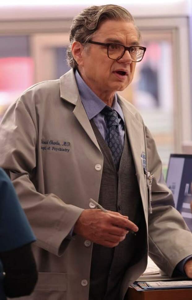 Dr. Charles standing at a desk about to sign something on Chicago Med S10 E1