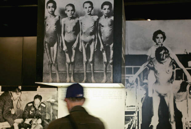 Израильский солдат рассматривает фото жертв нацистских экспериментов над людьми
