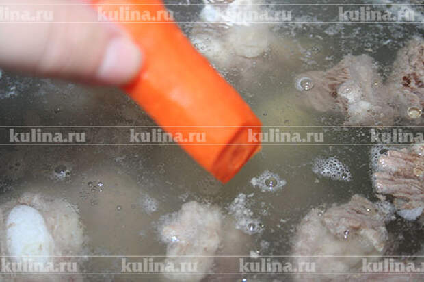 Когда пена будет снята, выложить в суп овощи - лук и морковку. 