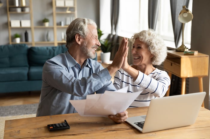 Retired couple high-fiving their RMD strategy.
