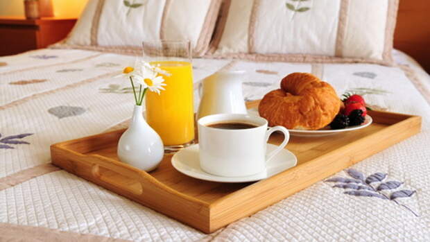 Tray with breakfast on a bed in a hotel room