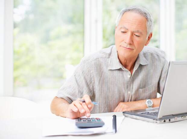 A person sitting at a table with a laptop and calculator.