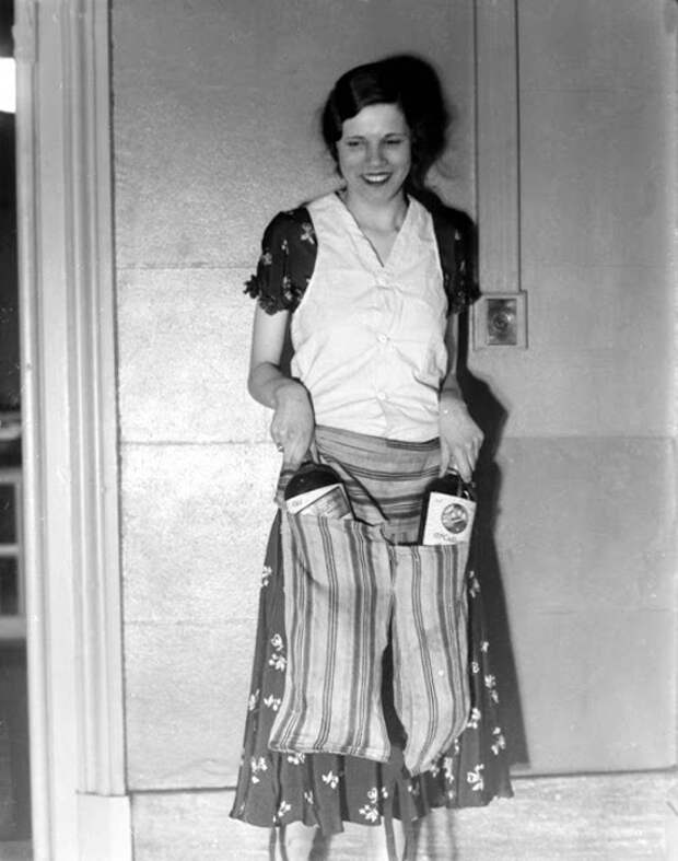 Эстелла Земон показывает накладной пояс-фартук, позволяющий пронести бутылки алкоголя мимо охранников. 18 марта 1931г. Фото: AP Photo.