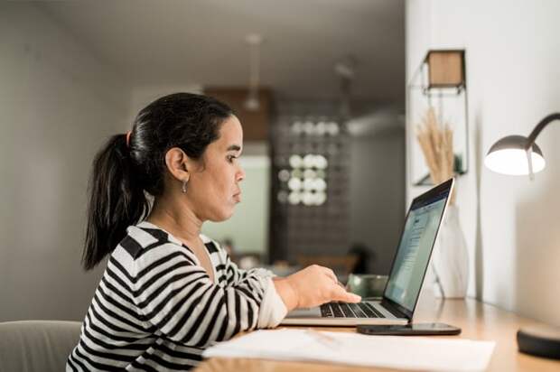 Person sitting at desk typing on laptop.