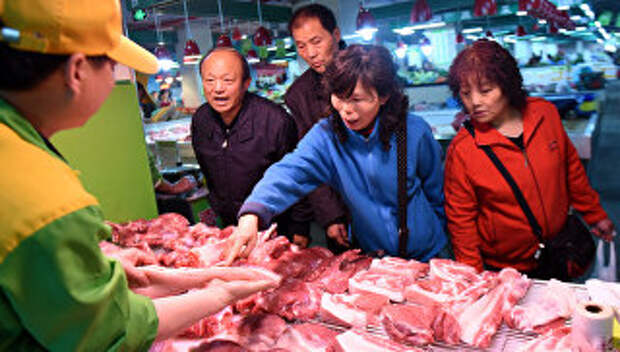 Покупатели выбирают свинину в супермаркете в Ханчжоу, Китай
