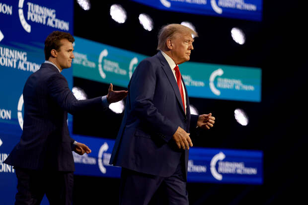 Дональд Трамп выходит на сцену после того, как его представил Чарли Кирк (слева) на конференции Turning Point Action, Уэст-Палм-Бич, Флорида, 15 июля 2023 года