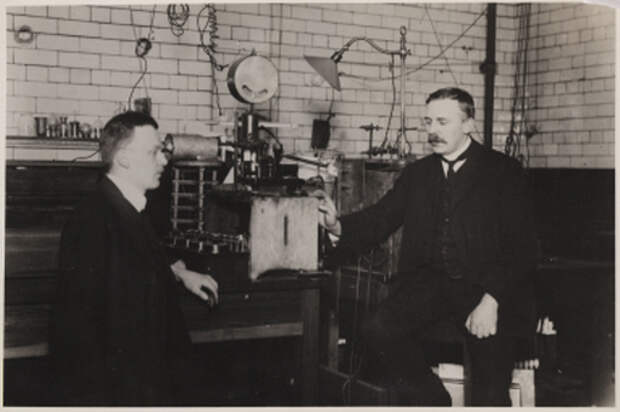 Photograph of Rutherford and Geiger with their apparatus for counting alpha particles. Born in New Zealand, Ernest Rutherford (1871-1937) was a pioneering nuclear physicist who discovered the alpha, beta and gamma rays of radiation. In 1907, he began working with the German physicist Hans Wilhelm Geiger (1882-1945), extending his study of alpha particles. Together they worked on a radiation detector invented by and named after Geiger, and developed the scintillation screen for observing alpha particles. In 1908 Rutherford was awarded the Nobel Prize for Chemistry.