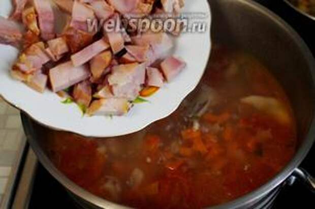 В солянку ввести нарезанное мясо,