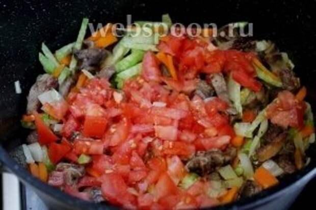 Добавить нарезанный помидор в казан к обжарке мяса с овощами.