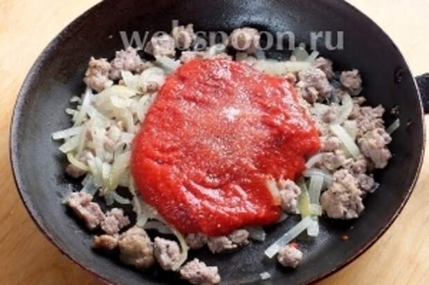 На оставшемся масле немного обжарьте (на среднем огне) фарш, лук и нарубленный чеснок. Через 5 минут добавьте томаты, сахар, посолите по вкусу.