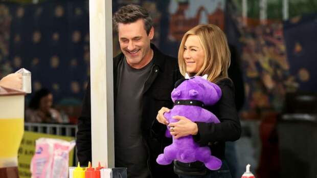 jon hamm and jennifer aniston playing a carnival game