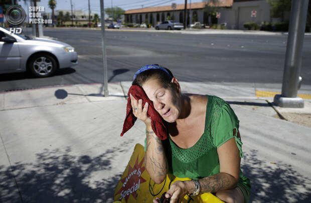 США. Лас-Вегас, Невада. Промоутер Аманда Уэлле охлаждается мокрым полотенцем во время работы. (AP Photo/John Locher)