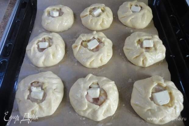 Данное количество теста я делю на 10 равных частей. Каждую часть раскатываю в кружок (края потоньше), на середину выкладываю начинку и защипываю края. Выкладываем на противень, смазываем яичным желтком, смешанным с молоком, и в каждый мини-курник кладем по кусочку сливочного масла.