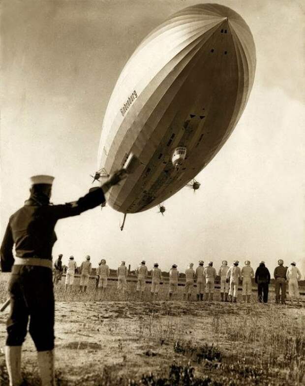 Американский работник ангара регулирует причаливание немецкого дирижабля, 1936 г.