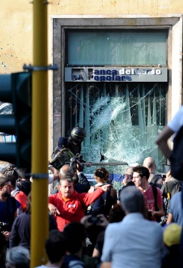 Protesters break the window of a bank du
