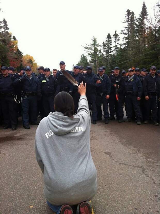 Женщина просит полицейских не применять силу на протестующих в Нью-Брансуике, Канада, октябрь 2013. Протест против добычи сланцевого газа. демонстрации, женщины, кадры, общество, протест, сильные женщины, сильные фотографии, фото