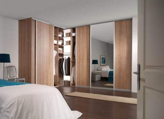 Угловой шкаф-купе в спальне с деревянными и зеркальными дверями