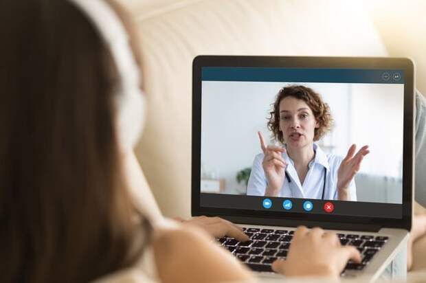 A woman talks to a doctor via her computer