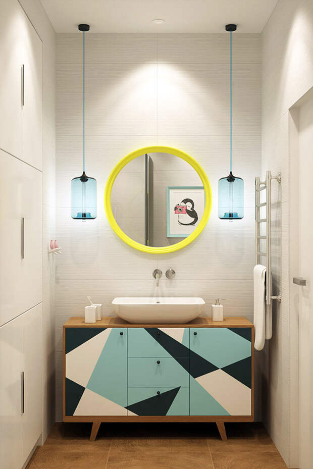 Круглое зеркало в желтой раме и тумба с геометрическим рисунком в ванной комнате фото