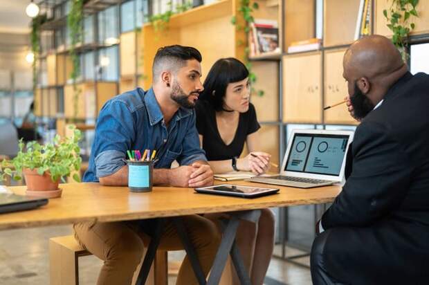 Couple meeting with banker in an office.