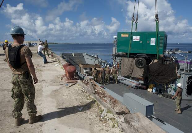 130707-N-SK590-259 EBEYE, Marshall Islands (July 7, 2013) U.S. Navy Sailors and Marshallese pier workers unload a reverse osmosis water system from a landing craft utility (LCU) during Pacific Partnership 2013. The filtration unit, provided by the U.S. A