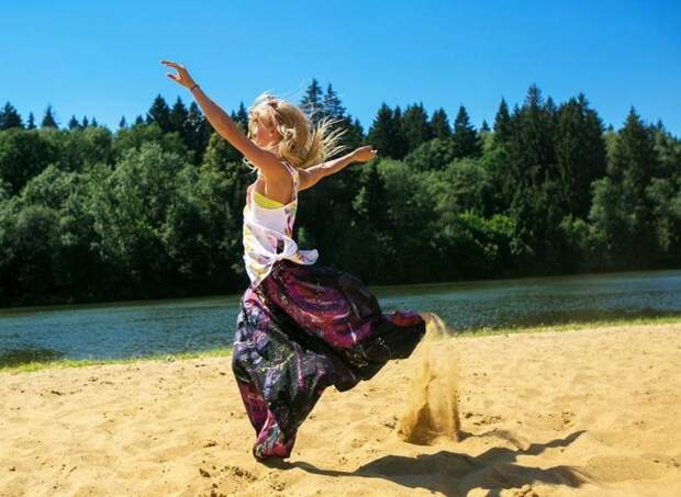 Девушка в восточных брюках, сшитых своими руками, бежит по песку