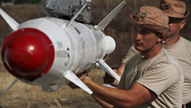 Российские военные подвешивают высокоточную ракету Х-25 к самолету Су-24 на авиабазе Хмеймим в Сирии