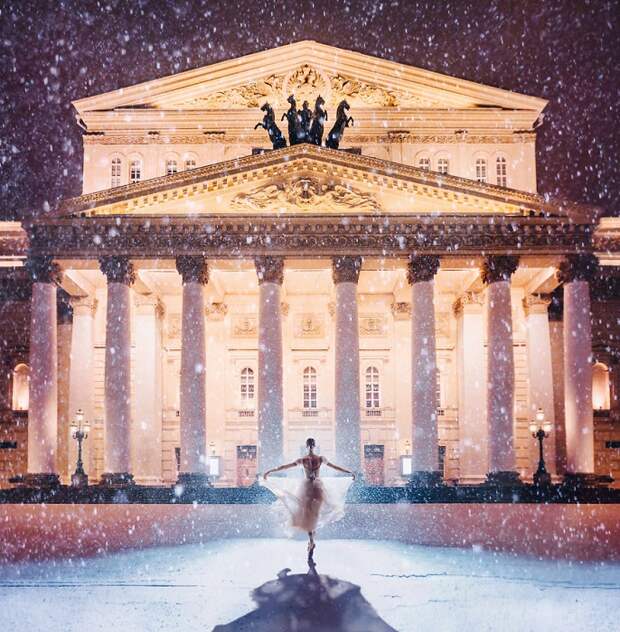 Хрупкая фигурка балерины застыла под падающим снегом перед освещенной громадой театра оперы и балета.