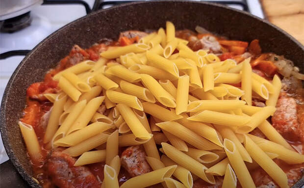 Высыпаем сухие макароны на сковороду и добавляем мясо: готовим пасту без варки