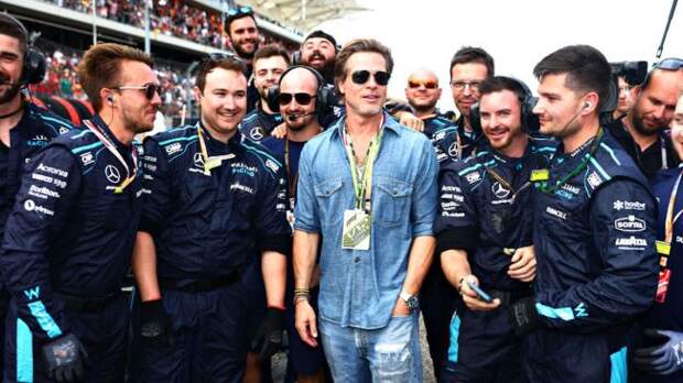 brad pitt posing on an f1 race track