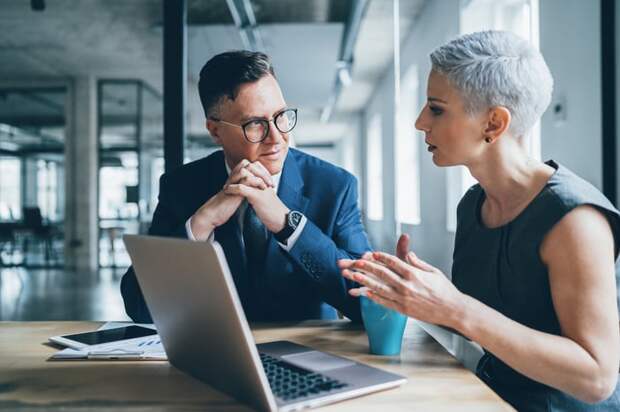 Two businesspeople discussing something in an office.